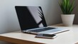 © pinporn manosri - Modern Workspace Setup Featuring Laptop and Smartphone on Wooden Desk with Potted Plant, Perfect for Remote Work, Productivity, and Minimalist Aesthetic