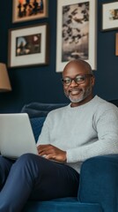 Aufkleber - A man is sitting on a couch with a laptop in front of him
