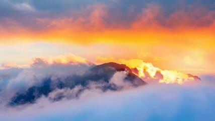 Wall Mural - golden sunset light filters through soft, misty clouds, highlighting the majestic silhouette of moun
