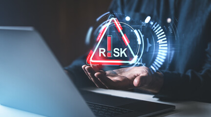 Poster - A person holds a digital risk warning symbol with a futuristic overlay, set against a dark background. Concept of risk management
