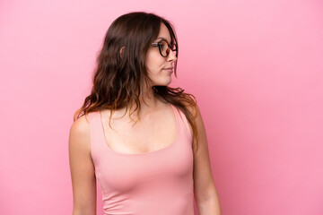 Wall Mural - Young caucasian woman isolated on pink background looking to the side