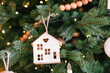 © reddish - Wooden house ornament hanging on a Christmas tree this holiday