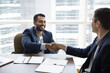 © fizkes - Cheerful young Indian businessman shaking hands with Caucasian business partner after negotiation, closing deal, contract, talking and laughing, getting agreement, investment for startup