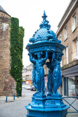 Wall Mural - A blue Wallace fountain in a street in the town of Villedieu-les-Poêles in Normandy in France