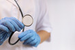 © Mariia - Doctor or nurse in gloves with stethoscope. Medicine and health concept. Pediatrician in white coat with stethoscope. Woman, medical and cardiac monitoring instrument, white background. Treatment