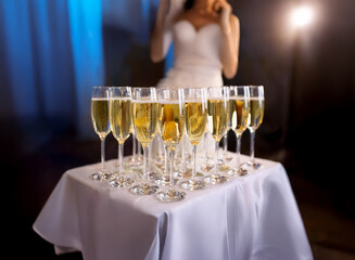 Aufkleber - A table with white linens and glasses of champagne sit in front of a bride.
