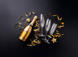 Poster - A bottle of champagne, two champagne flutes, and gold confetti arranged on a black background.