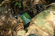 © seeasign - A soldier in tactical gear operates a control tablet in the field, using technology for reconnaissance with an aerial view display on the screen.