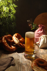 A mug with beer and traditional German bretzels in Bavarian rustic style