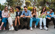 © Lomb - Diverse young people friends using smartphones together outdoors social media technology lifestyle modern generation connection