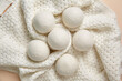 © mikeosphoto - Eco-Friendly Wool Dryer Balls on Cozy Knitted Fabric Background, Top View, Flat Lay