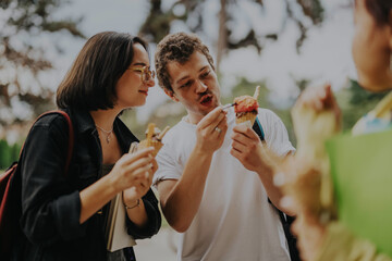 Poster - A group of multicultural students takes a break between classes to enjoy ice cream together in a park, showing friendship and relaxation.