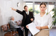 © JackF - Portrait of upset young businesswoman holding papers in hands while standing in office lobby with disgruntled boss pointing with hand at door in background