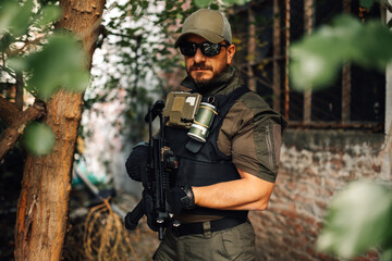 Wall Mural - Soldier wearing tactical gear and holding assault rifle in urban environment