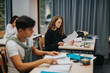 © qunica.com - A group of students engaged in study, seated at desks in a modern classroom. The scene represents focus, learning, and academic collaboration, highlighting the educational environment and youthful