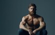 © LimeSky - Relaxed bearded male model sitting against a grey backdrop showcasing his muscular physique Themes of men s health self care and fashion