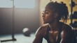 © ALLAI - Black female athlete resting in gym after workout, concept of strength and resilience in fitness