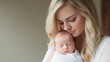 © Narongsag - Loving Mother Holding Newborn Baby in Studio Setting