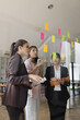 © SOMKID - Asian businesswoman teamwork planning with sticky notes and new ideas on a glass wall, Business people brainstorming strategy and new ideas concept, startup worker meeting,