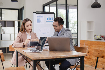 Wall Mural - Two business people working with business financing accounting banking and laptop with finances analysis report at desk in office. 