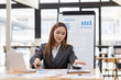 © SOMKID - young asian businesswoman working on laptop with finances analysis report at desk in office, business financing, accounting banking,