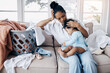 © peopleimages.com - Mother, home and hug baby for comfort, tired woman and laundry basket with clothes to fold. Mama, embrace daughter and cleaning fatigue in living room, burnout and messy chaos of washing or child