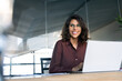 © Stock 4 You - Smiling portrait professional it specialist latin hispanic business lady working on laptop pc sitting in modern office. Young middle eastern indian woman using computer technology for work. Copy space