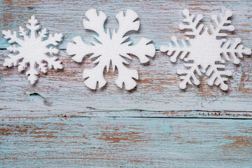 White decorative snowflakes on blue wooden background, copy space