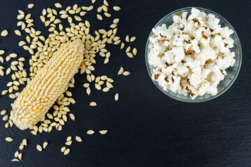 Wall Mural - Heap of raw and cooked popcorn grains isolated on black background.