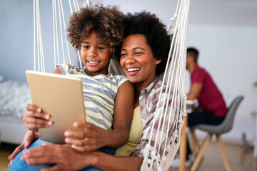 Wall Mural - african american mother and daughter watching entertainment on digital tablet at home