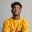 © Ayan - Young Black man in yellow sweater smiling at the camera.