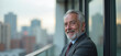 © Yury - Confident Senior Businessman Smiling Against Urban Skyline