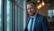 © Yury - Mature businessman with serious expression contemplating in modern office environment