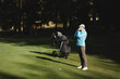 © Nadzeya - Female golfer looks into rangefinder and measures distance