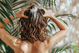 Woman washes short hair in shower, her hands lathering shampoo into her wet hair.