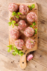 Wall Mural - raw meatballs on wooden board with herbs