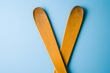 Top view of two old wooden skis on a blue background with copy space, Generative AI