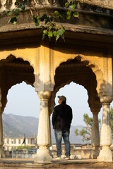 Wall Mural - Man under archway with mountain view