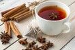 © SerPak - A warm cup of spiced tea is placed on a wooden table, surrounded by cinnamon sticks and star anise pods, with a tea bag resting nearby. The inviting aroma fills the air, creating a cozy atmosphere per
