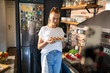 © Geber86 - Young woman filming cooking tutorial in kitchen with fresh vegetables and eggs