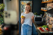 © Geber86 - Young woman filming cooking tutorial in kitchen with fresh vegetables and eggs