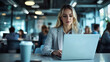 © Lilimanatasa - A young woman is working on a laptop in a modern office