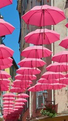 Wall Mural - Rows of pink umbrellas above the streets of the old town in Grasse, France. Vertical