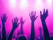 © Pairat - A vibrant concert scene with raised hands silhouetted against colorful stage lights, capturing the energy and excitement of a live performance.
