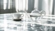 © cynz - A clear glass teapot and teacup on a white marble surface, casting subtle reflections in a minimalist arrangement. No text, no logo, wide angle shot, cinematic scene, 4k resolution