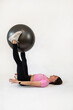 © RomanR - Caucasian slim woman trainer make pilates exercise with fitness ball isolated on white