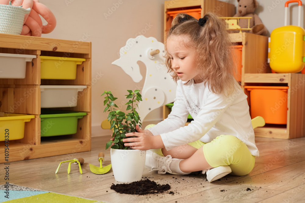 Little girl playing with plant soil at home