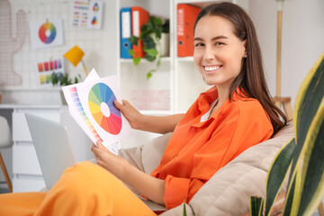 Poster - Young female graphic designer working with color palettes on armchair in office