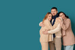 © Pixel-Shot - Man and two beautiful women in autumn clothes hugging on blue background. Polyamory concept
