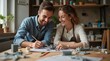 © Alex Pios - A close-up view of a couple working together on a model-building project at a table, surrounded by tools, glue, and various model parts. They are focused and engaged, sharing ideas